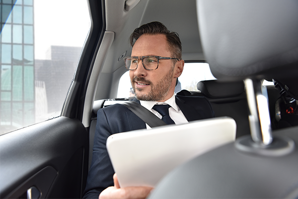 An image of a pleased looking business man being transported by taxi